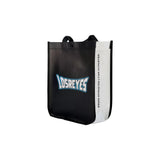 Minimalist black Los Reyes gift bag captured from a side perspective showing structure and handles. From athletes, for athletes