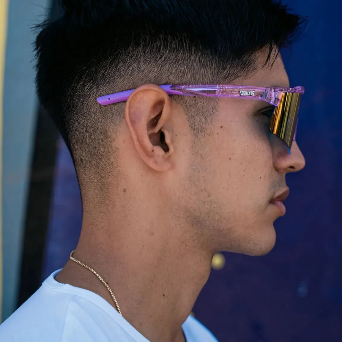 Profile lifestyle shot of LosReyes Prime Galaxy Mercury sports sunglasses, showing off the orange mirrored lens and translucent purple arms, built for performance and eye-catching urban style.