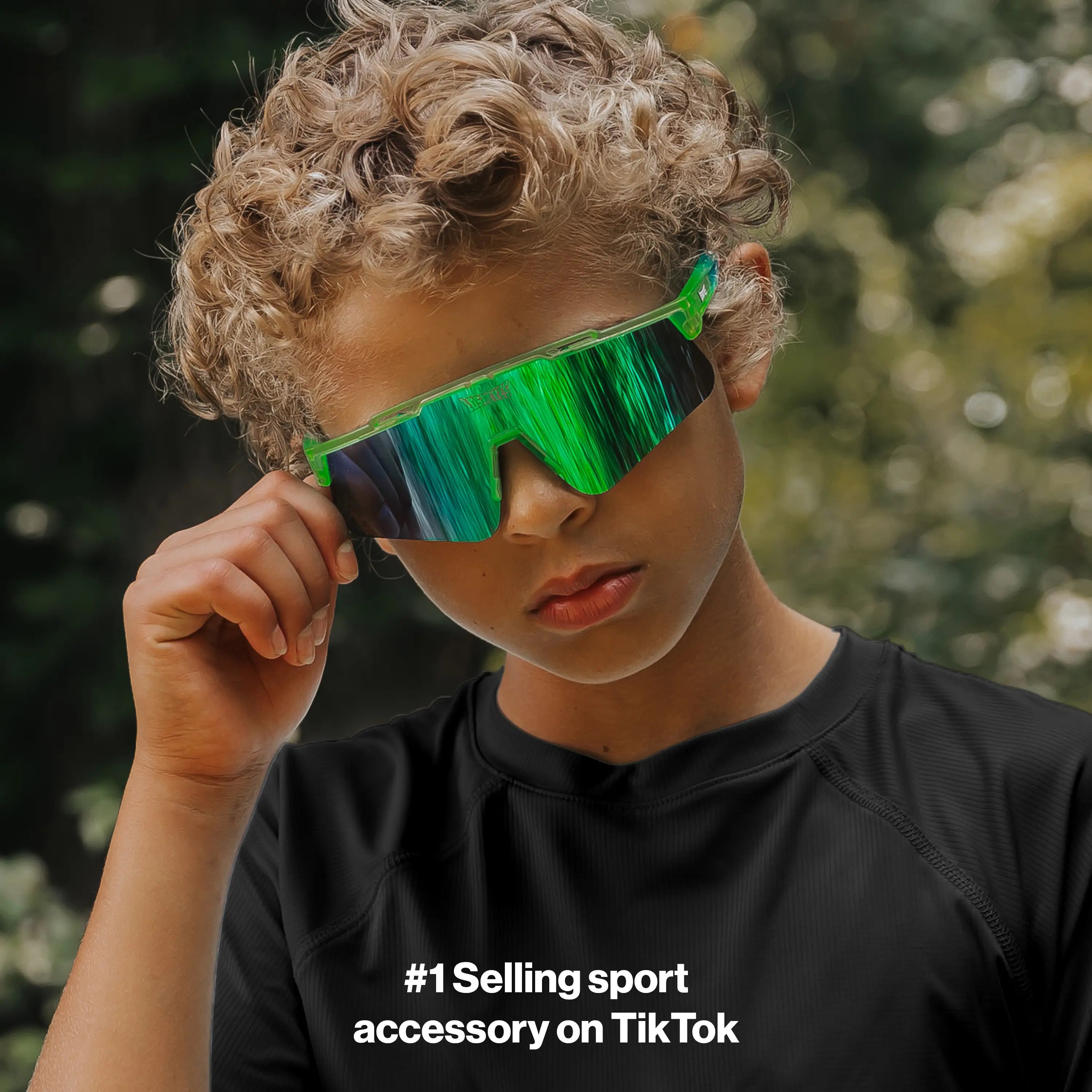 Youth lifestyle image of LosReyes Prime Jurassic Pterodactyl sunglasses in vibrant green with a mirrored shield lens and wraparound frame, designed for active outdoor wear and high-performance UV protection.
