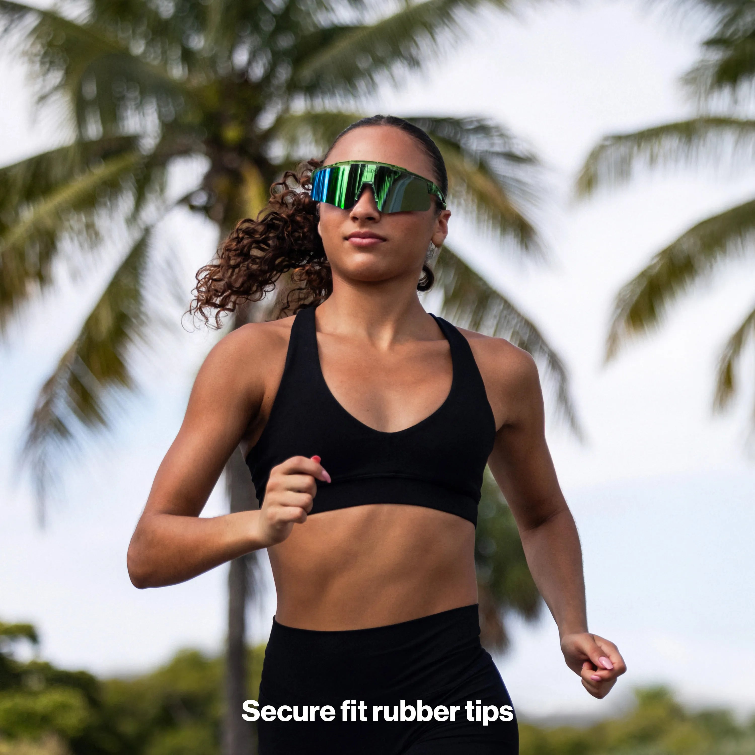 Athlete running outdoors wearing LosReyes Earth shades, featuring a mirrored blue lens and secure sport fit.