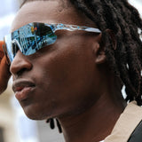 Close-up side view of Edge Ocean sunglasses showing clear frame details and blue mirrored lens reflection.