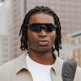 Front view of model wearing Edge Shadow sunglasses with dark shield lenses.