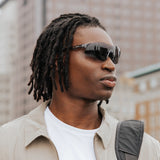 Side profile of model wearing Edge Shadow sunglasses with black wraparound lenses.