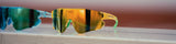 Colorful Elevate LosReyes sunglasses on a wooden surface with a blurred background, football official sunglasses