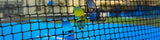Blue and yellow losreyes sunglasses on a tennis net with a blurred outdoor background