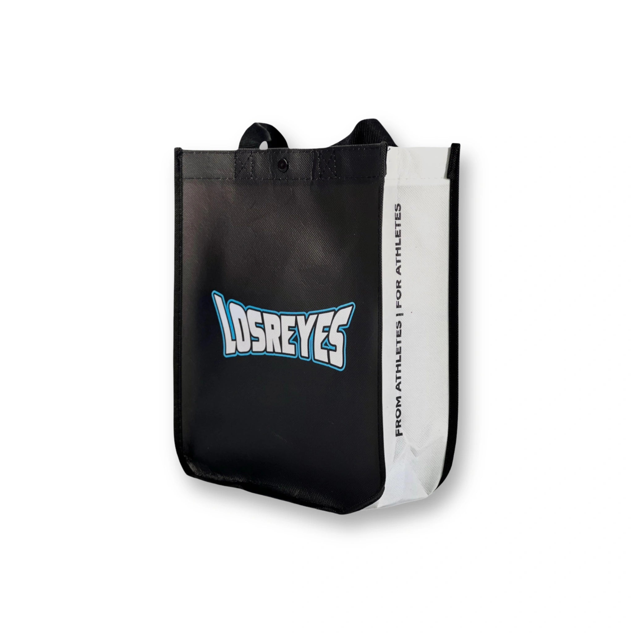 Minimalist black Los Reyes gift bag captured from a side perspective showing structure and handles. From athletes, for athletes