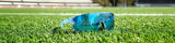 LosReyes blue raz elevate sport sunglasses resting on green turf football field for athletes and outdoor sports performance