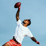 Athlete Ross500 making a one-handed football catch wearing LosReyes Cherry Elevate sports sunglasses, featuring polarized clarity and ultra-durable TR90 frames.