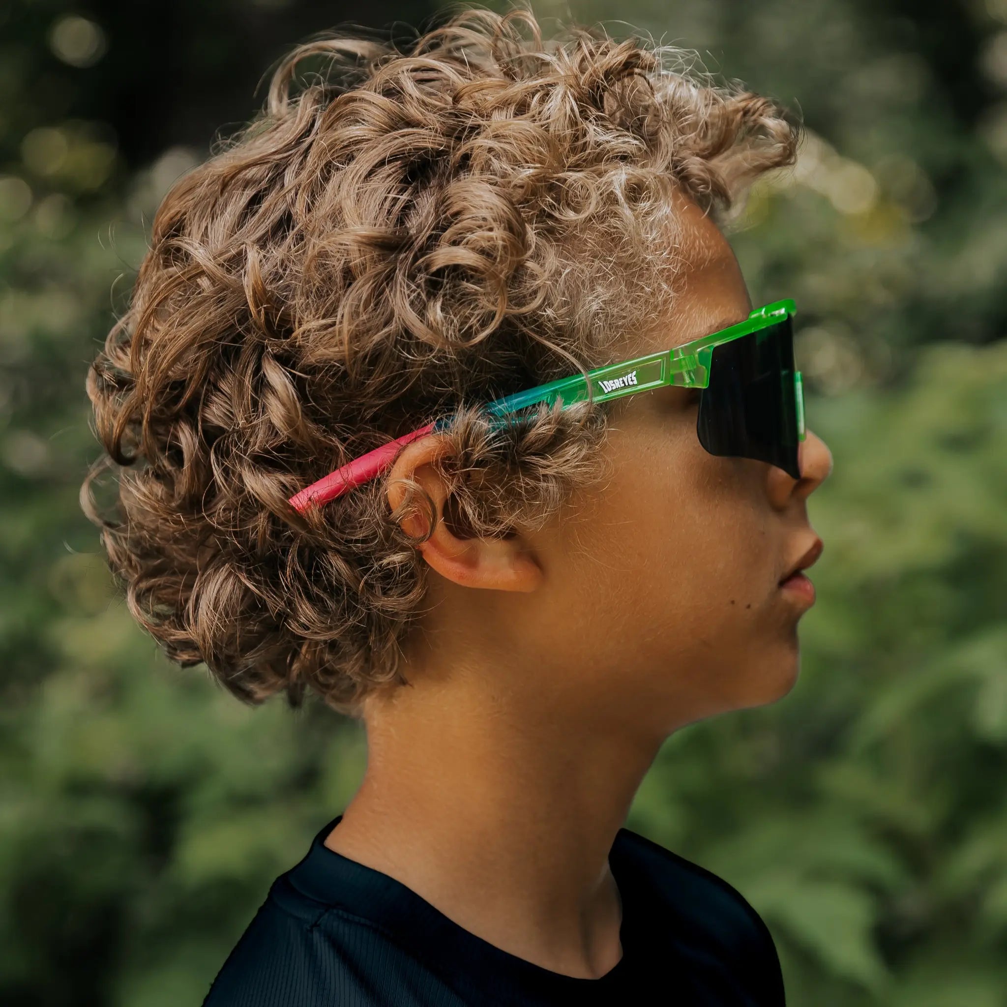 Youth wearing LosReyes Jurassic Series Pterodactyl green sunglasses outdoors