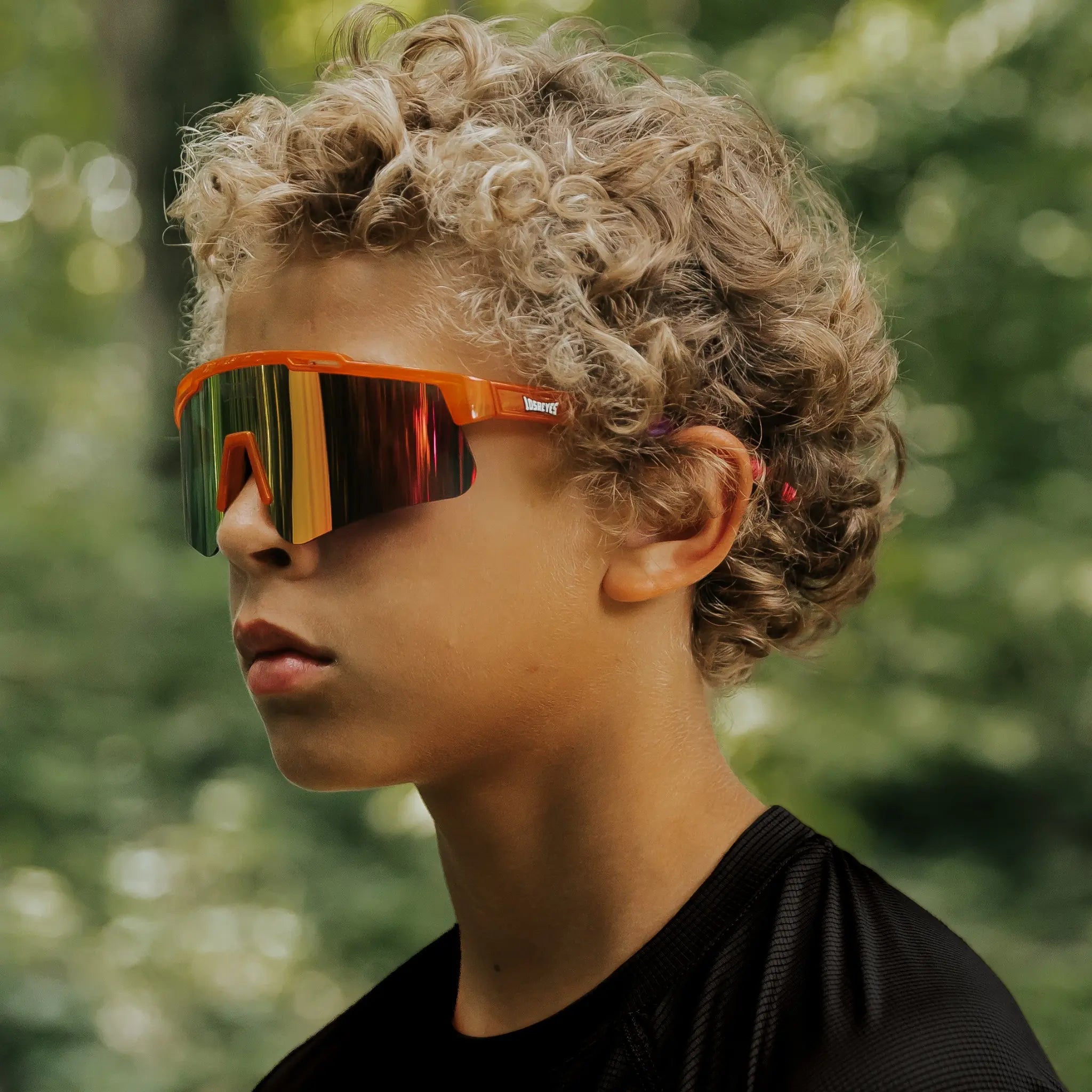 Youth wearing LosReyes Jurassic Series Triceratops orange sunglasses outdoors