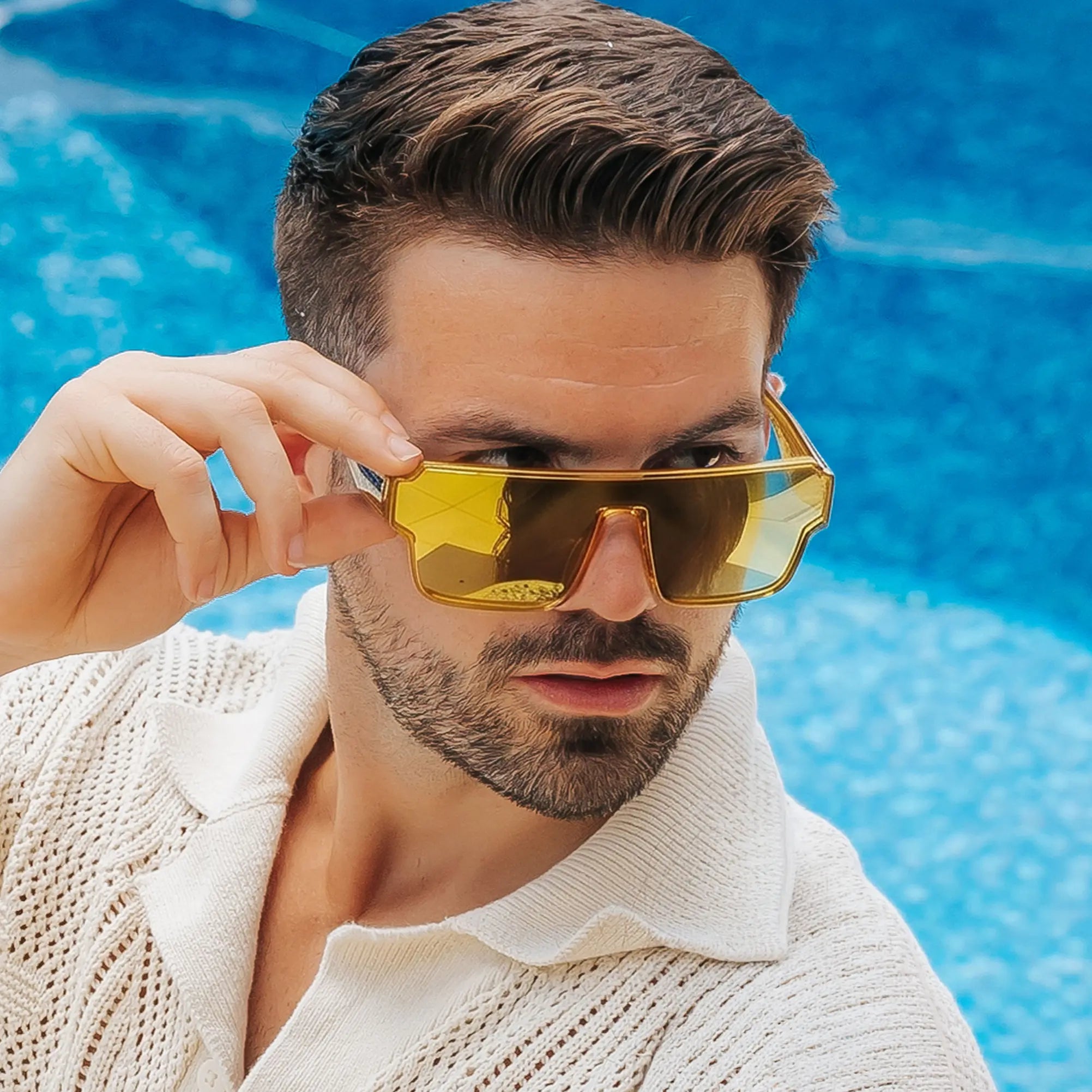 Man wearing LOSREYES Omega Apollon lifestyle sunglasses with gold frame and gold reflective mirror lens by the pool
