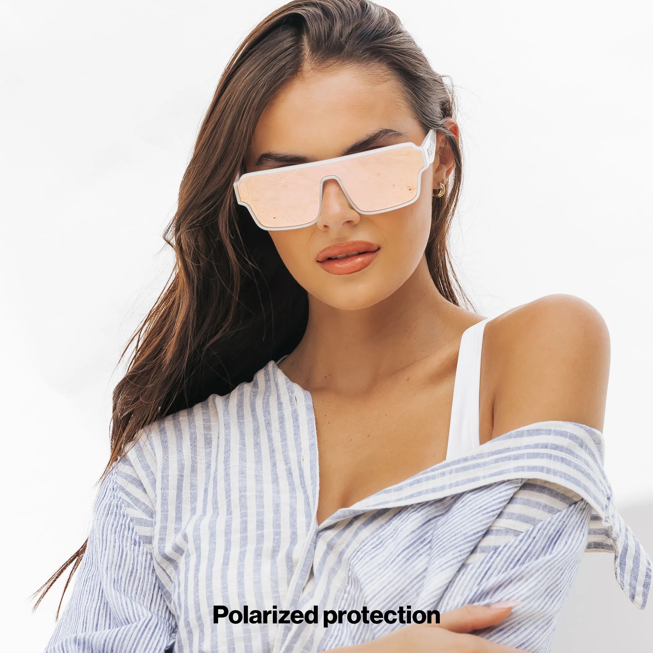 Woman wearing oversized pink lens and white frame Athena Omega collection sunglasses from LosReyes with a plain background