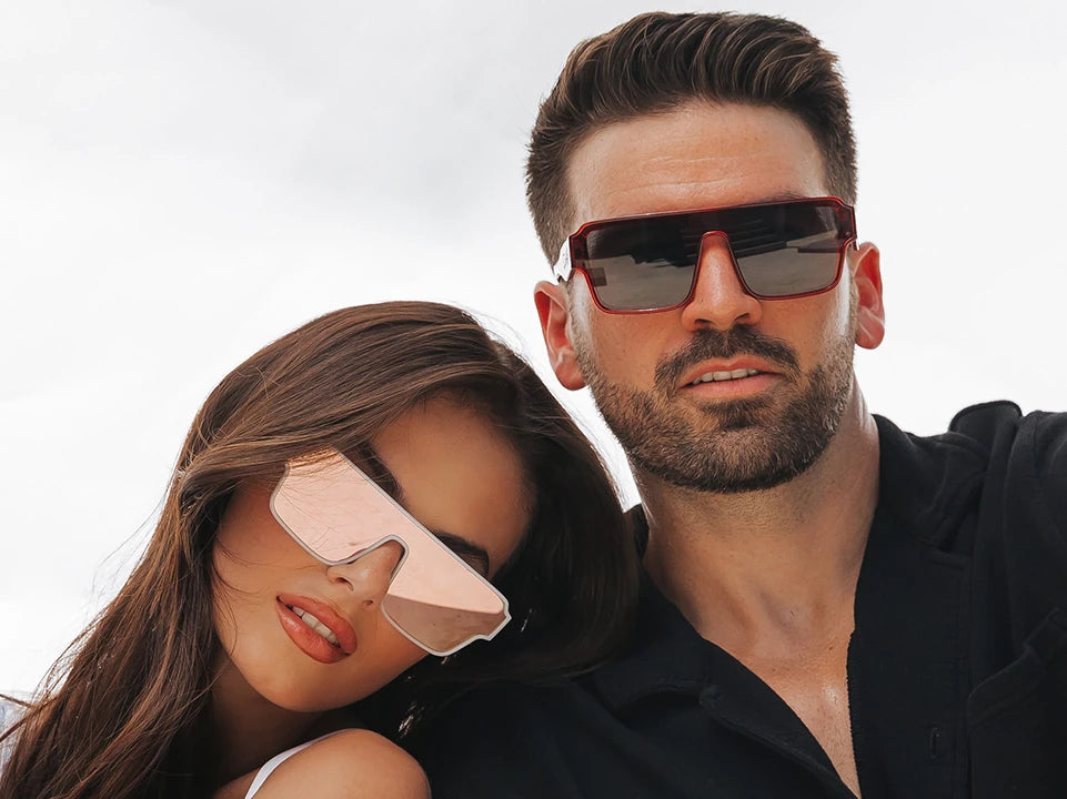 Stylish couple wearing oversized futuristic shield sunglasses from LosReyes
