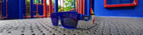 LosReyes Omega youth shield sunglasses in Superhero blue with red temple fade and mirrored lens, resting on a playground surface, UV400 kids performance eyewear