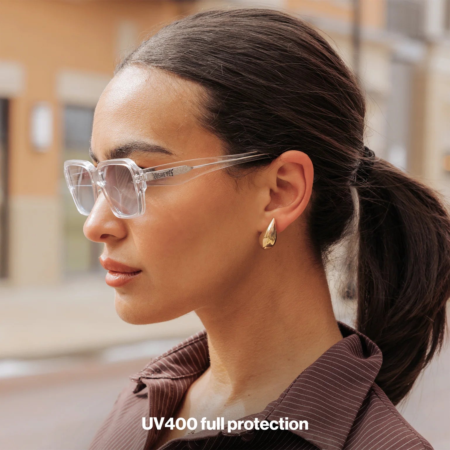 Woman wearing LosReyes Opus Monaco transparent frame sunglasses with gold earrings – clear luxury fashion eyewear