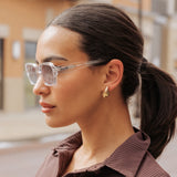 Woman wearing LosReyes Opus Monaco transparent frame sunglasses with gold earrings – clear luxury fashion eyewear