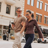 Couple walking in city wearing LosReyes Opus Monaco transparent sunglasses and Opus Positano black sunglasses with orange lenses