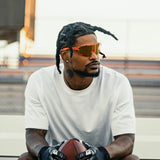 LosReyes Peach Elevate sunglasses worn by Ross500 while playing football, orange mirrored shield lens built for style and speed.