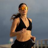 Runner wearing LosReyes Peach performance sunglasses, engineered with a mirrored shield lens, polarized glare reduction, and feather-light TR90 comfort for fast-paced training.