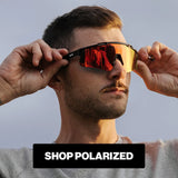 Man wearing LosReyes polarized sports sunglasses with red mirrored lenses outdoors.
