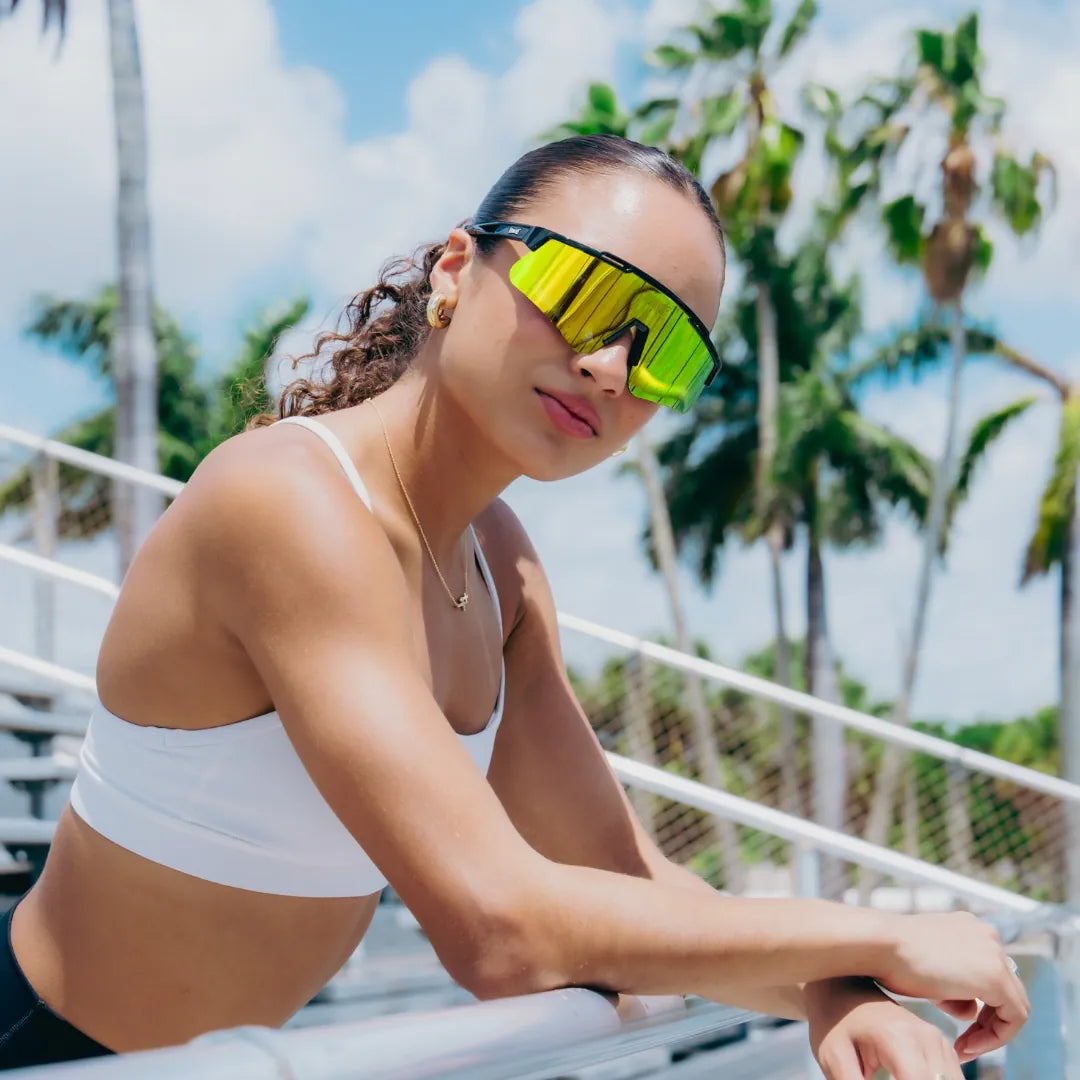 Lifestyle photo of woman wearing LosReyes Prime Polarized Yellow wraparound sports sunglasses featuring shield-style mirrored lenses, black high-performance frame, and UV400 protection for athletic outdoor training
