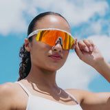 Woman wearing LOSREYES Prime USA 250 Limited Edition sunglasses with white speckle frame and red mirror lens against a bright blue summer sky