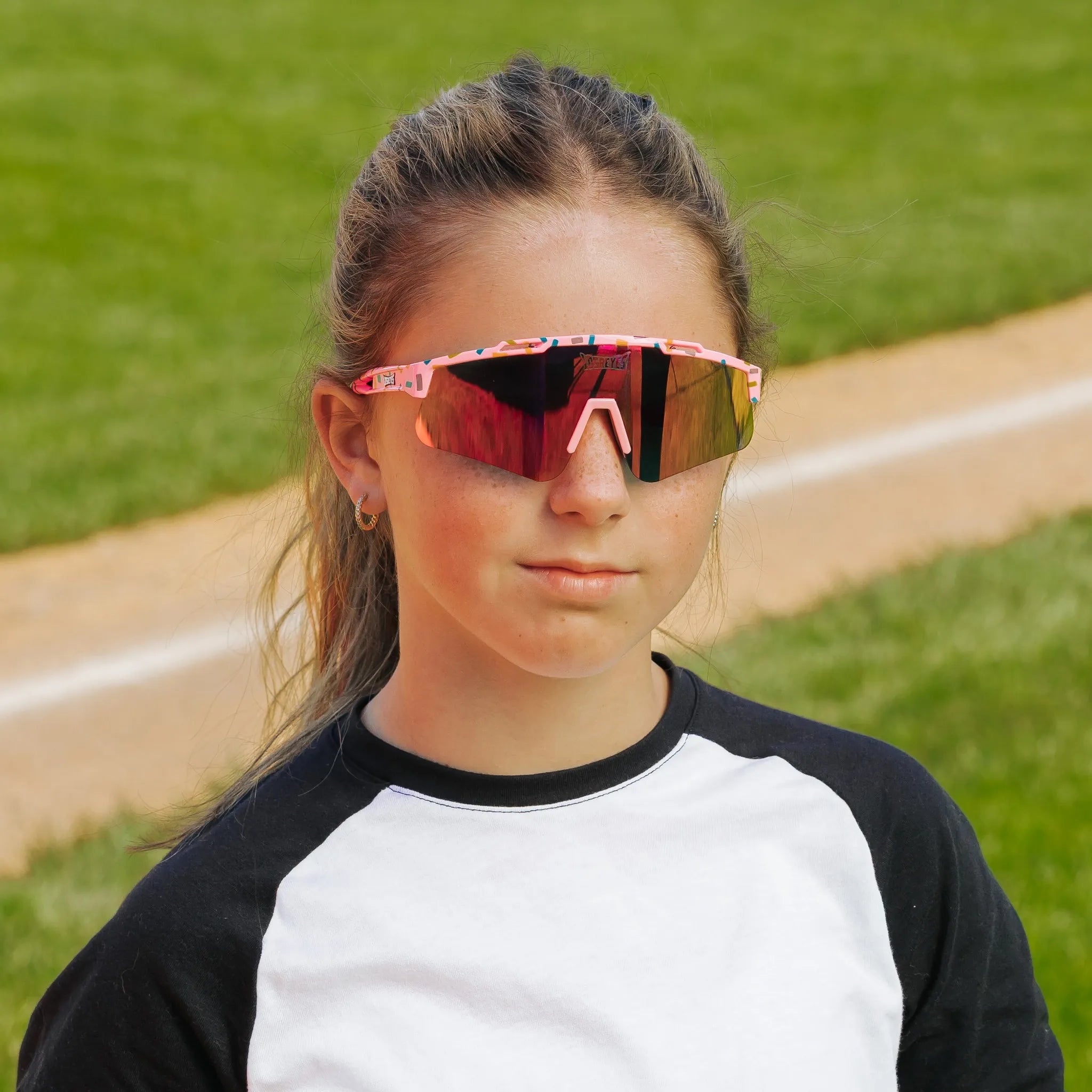 LosReyes PrimeYouth Candy Collection "Cream Pink" youth sunglasses with UV400 protection on baseball field