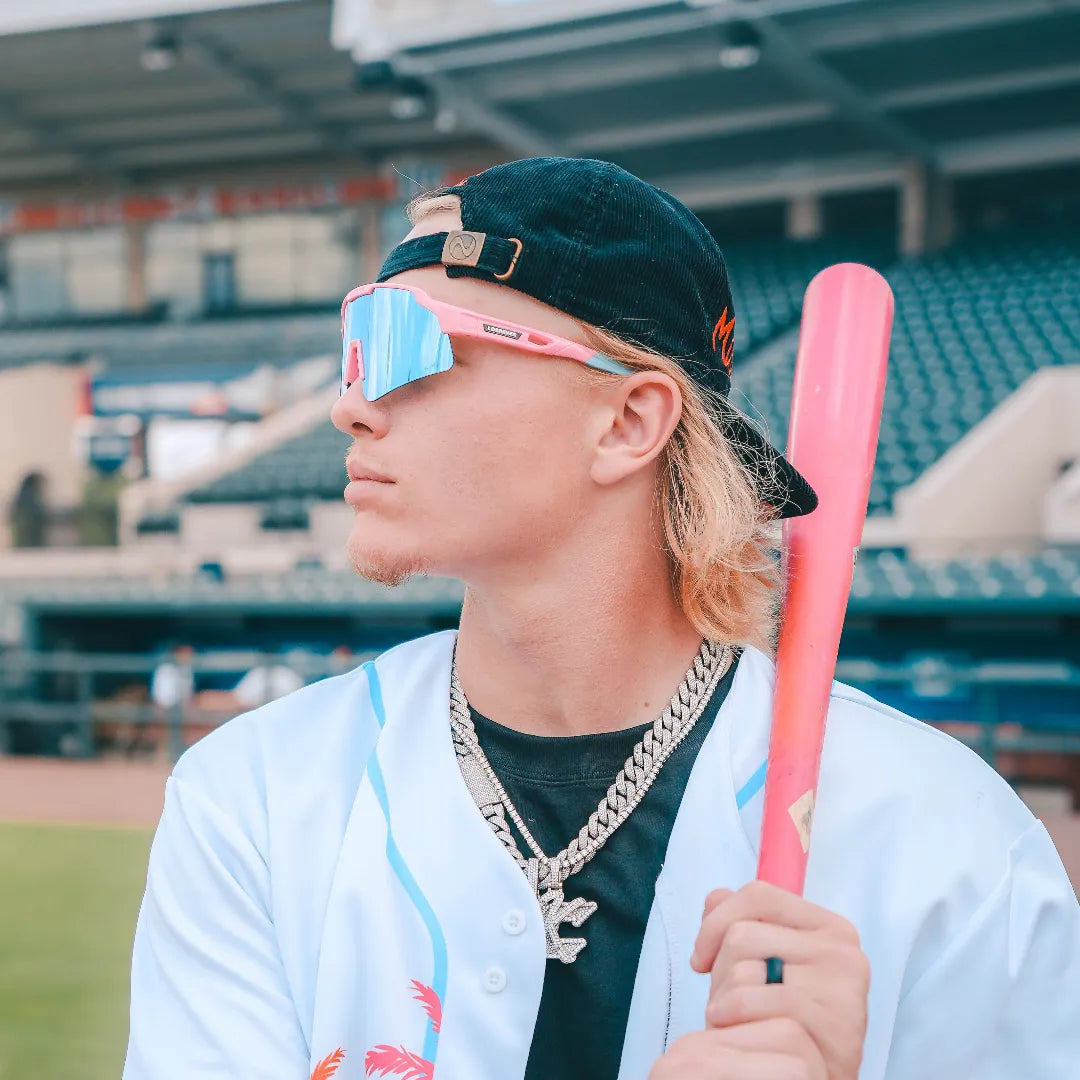 LosReyes Showtime Max Clark Original sunglasses with mirrored blue lenses worn during baseball pose with pink bat, showcasing bold design and high-contrast fit.