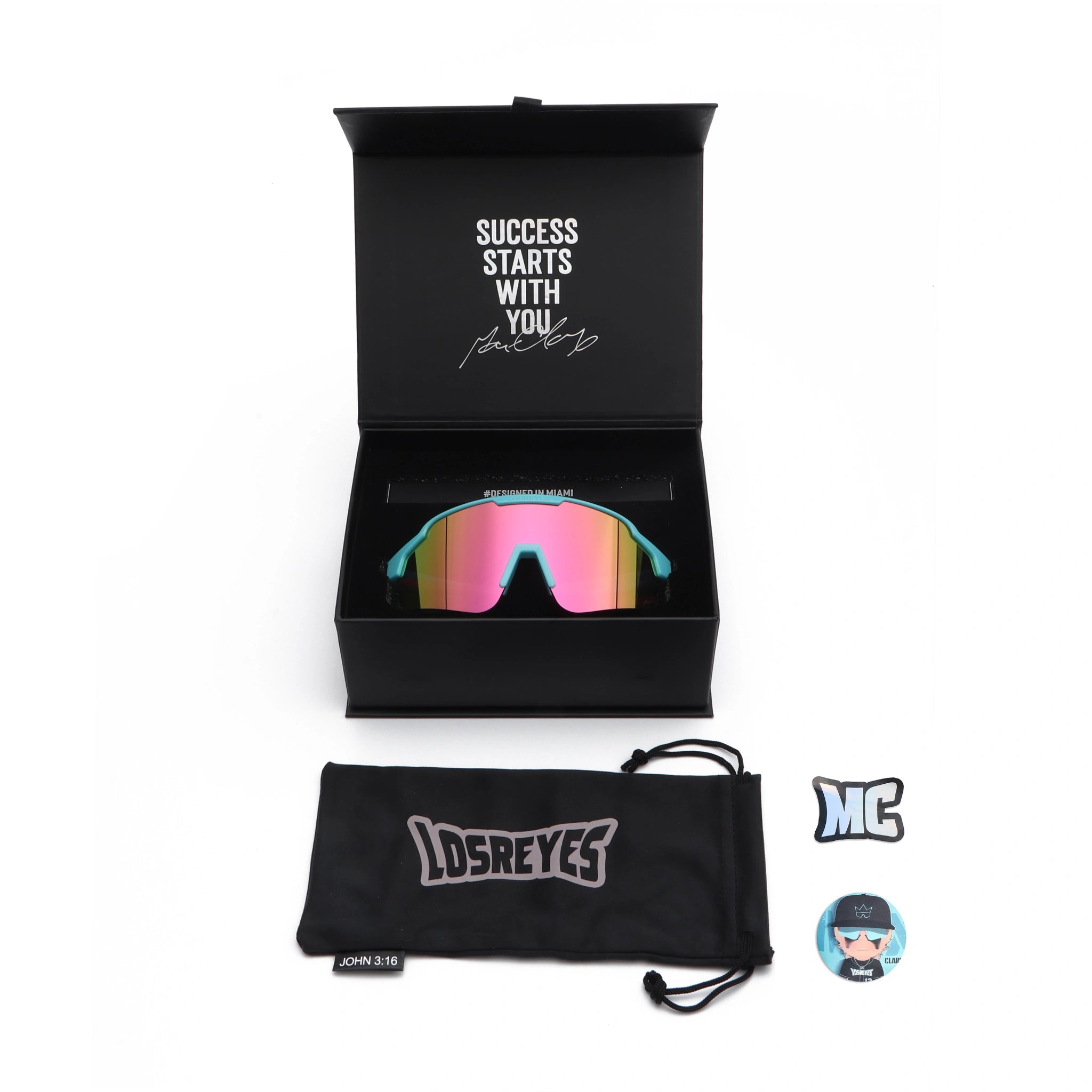 Complete LosReyes Showtime Max Clark Reversed sunglasses packaging showing custom box with motivational quote, branded case, and collectible sticker set.