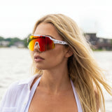 Woman wearing LOSREYES Showtime Limited Edition USA 250 sunglasses, red white and blue speckled colorway from the 4th of July drop, at the waterfront
