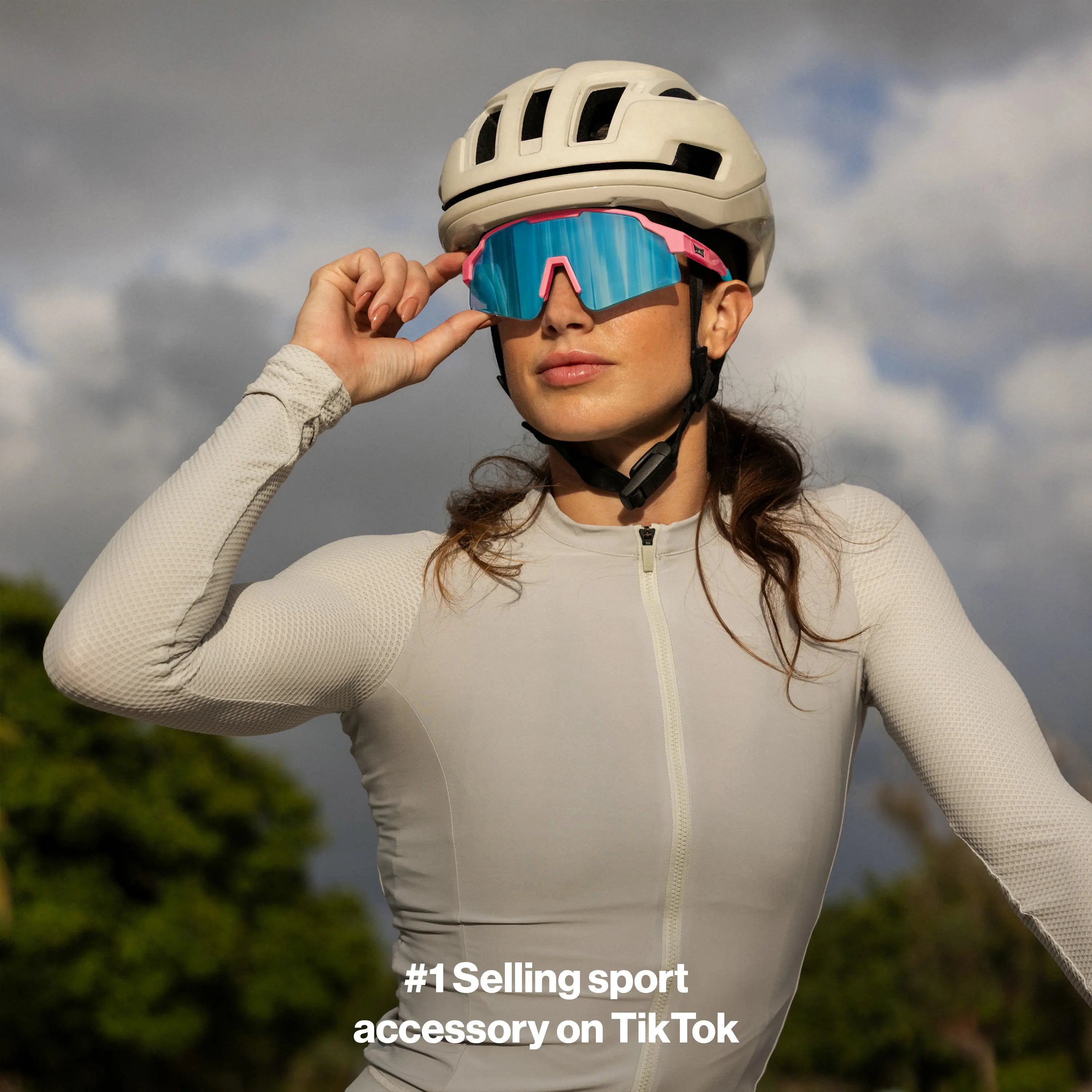 LosReyes SHOWTIME Vice cycling sunglasses with mirrored blue lens and pink frame, worn by cyclist adjusting fit before ride