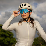 LosReyes SHOWTIME Vice cycling sunglasses with mirrored blue lens and pink frame, worn by cyclist adjusting fit before ride