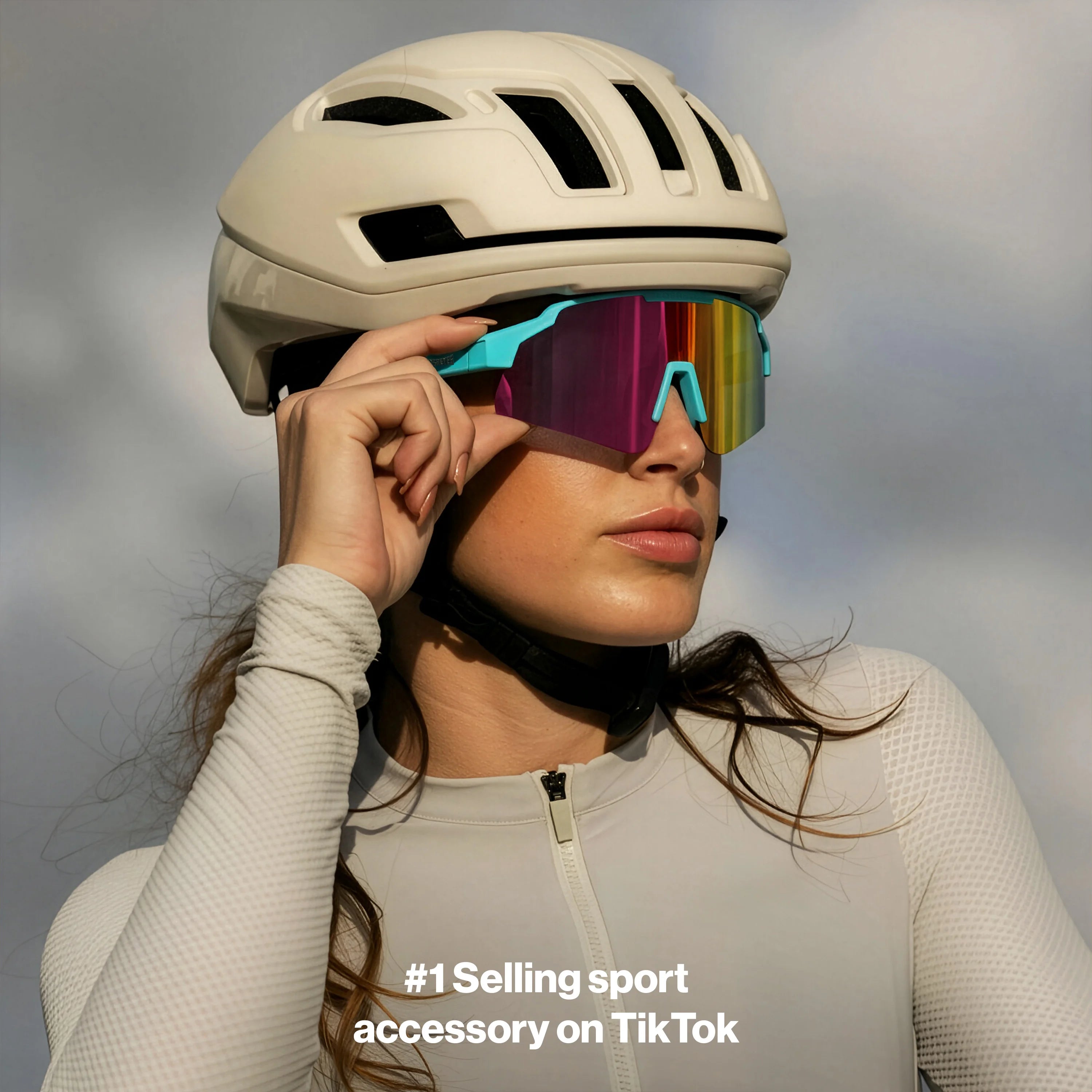 LosReyes SHOWTIME Vice Reversed sunglasses with mirrored multicolor lens and turquoise frame, worn by cyclist adjusting fit under helmet