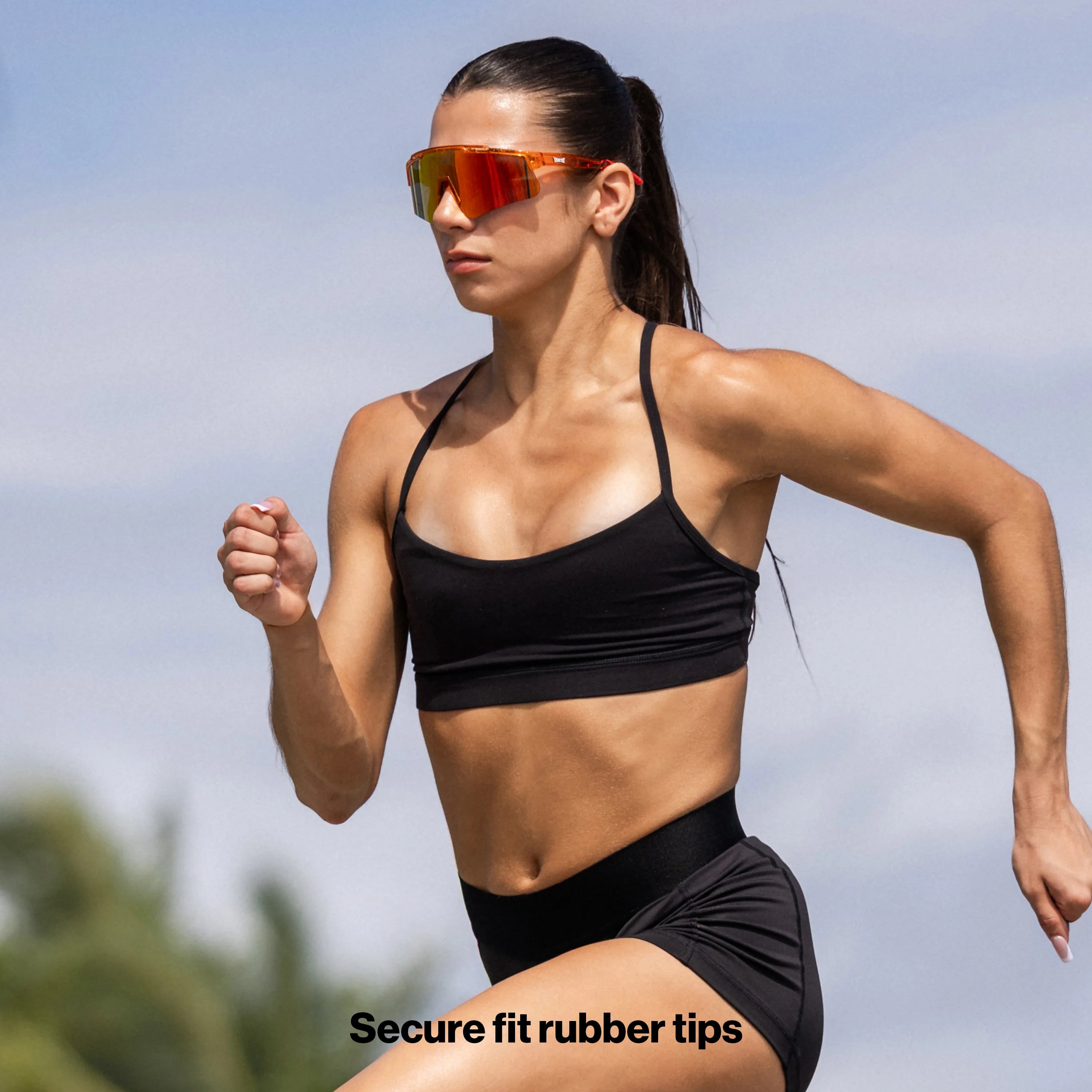 Female runner wearing LosReyes mars performance running sunglasses during a sprint workout outdoors.