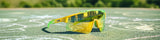 Neon yellow and green sport banana shield sunglasses on outdoor court surface in bright sunlight