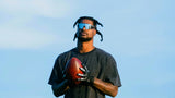 Ross500 holding a football wearing sunglasses with a city skyline in the background